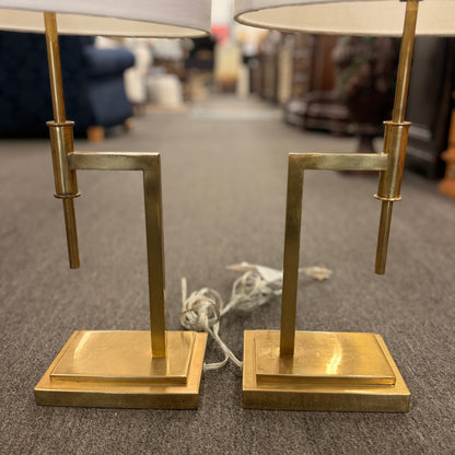 Matching pair of contemporary brass table lamps featuring stepped rectangular bases, angular geometric stems, and white fabric drum shades.