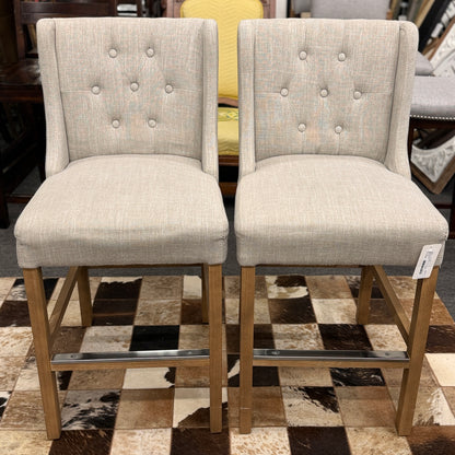 Set of two upholstered bar stools featuring wood and metal construction with comfortable fabric seats for kitchen islands or home bars.