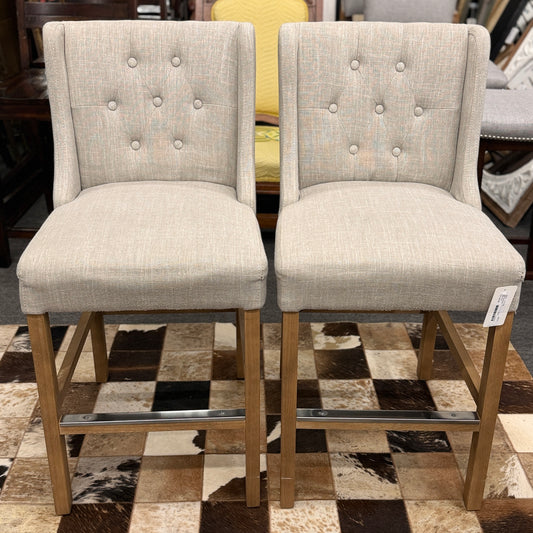 Set of two upholstered bar stools featuring wood and metal construction with comfortable fabric seats for kitchen islands or home bars.