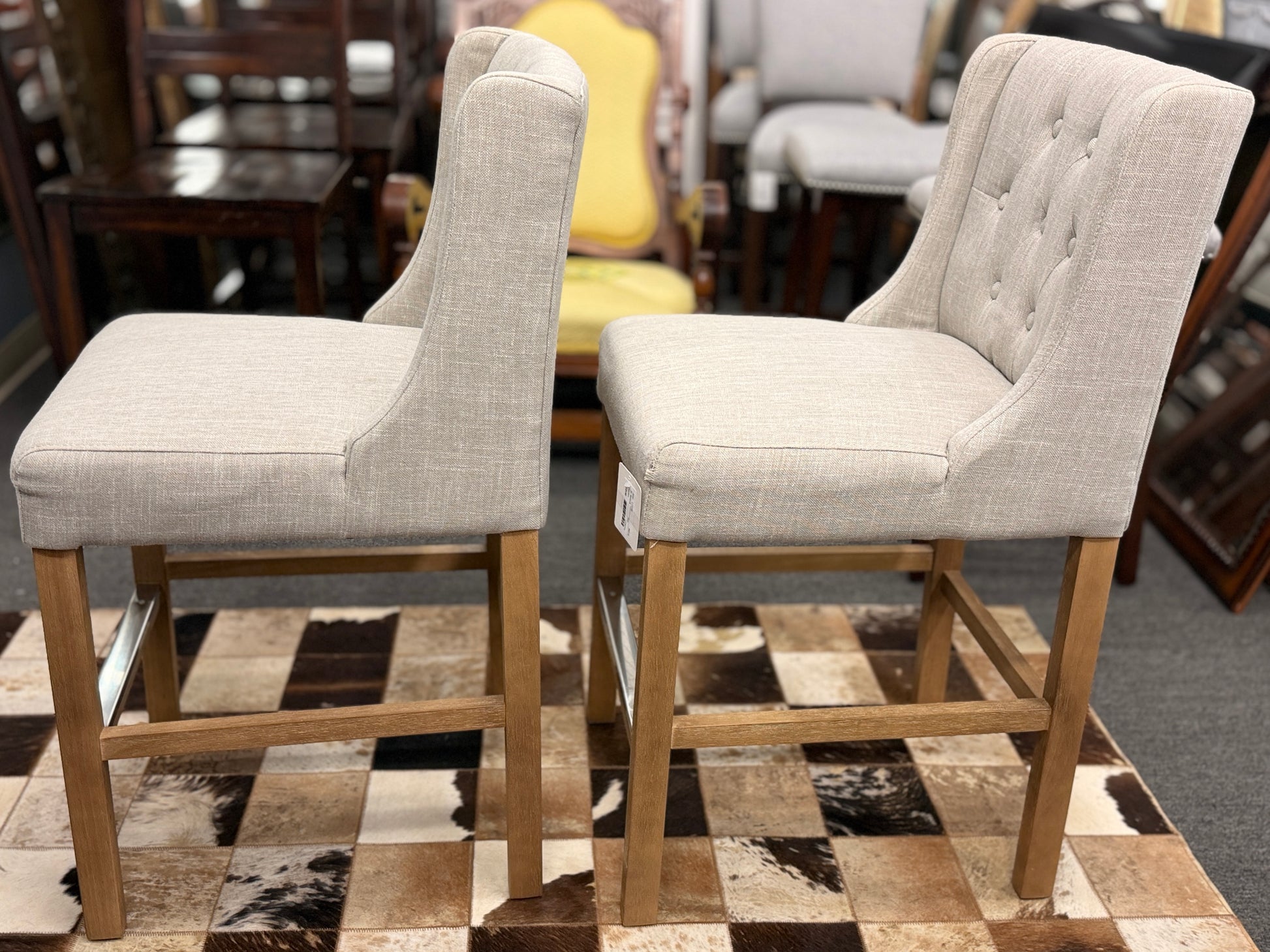 Set of two upholstered bar stools featuring wood and metal construction with comfortable fabric seats for kitchen islands or home bars.