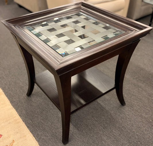 Square dark wood end table featuring a glass top with an intricate woven metal inlay and a lower display shelf.