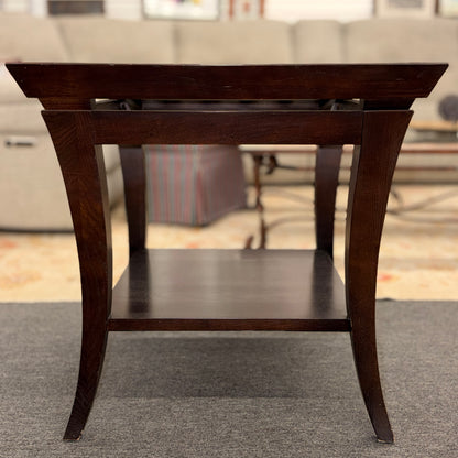 Square dark wood end table featuring a glass top with an intricate woven metal inlay and a lower display shelf.