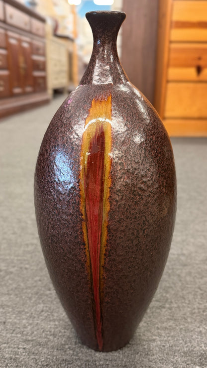 A tall teardrop-shaped ceramic vase featuring a textured mottled dark brown glaze with a vertical yellow and red-brown streak.