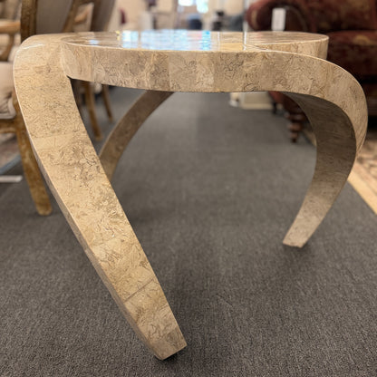 Tessellated stone end table featuring a polished light-colored stone mosaic, organic rounded triangular top, and sculptural curved three-leg base.