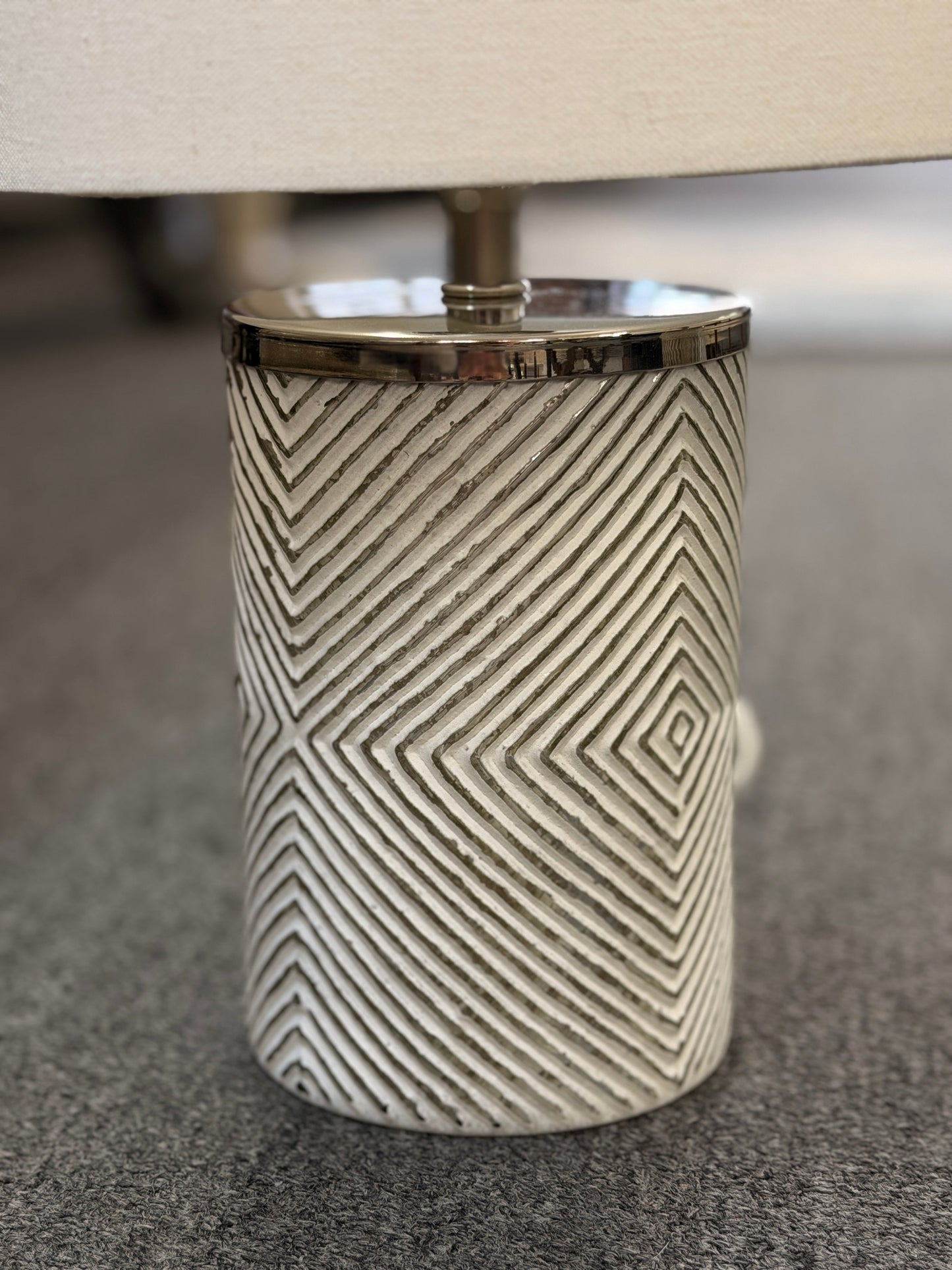 A pair of identical table lamps featuring textured white cylindrical ceramic bases with a geometric diamond pattern, white drum shades, and silver-toned hardware.