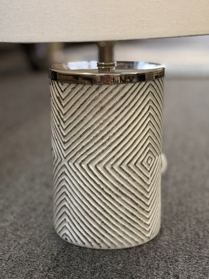 A pair of identical table lamps featuring textured white cylindrical ceramic bases with a geometric diamond pattern, white drum shades, and silver-toned hardware.