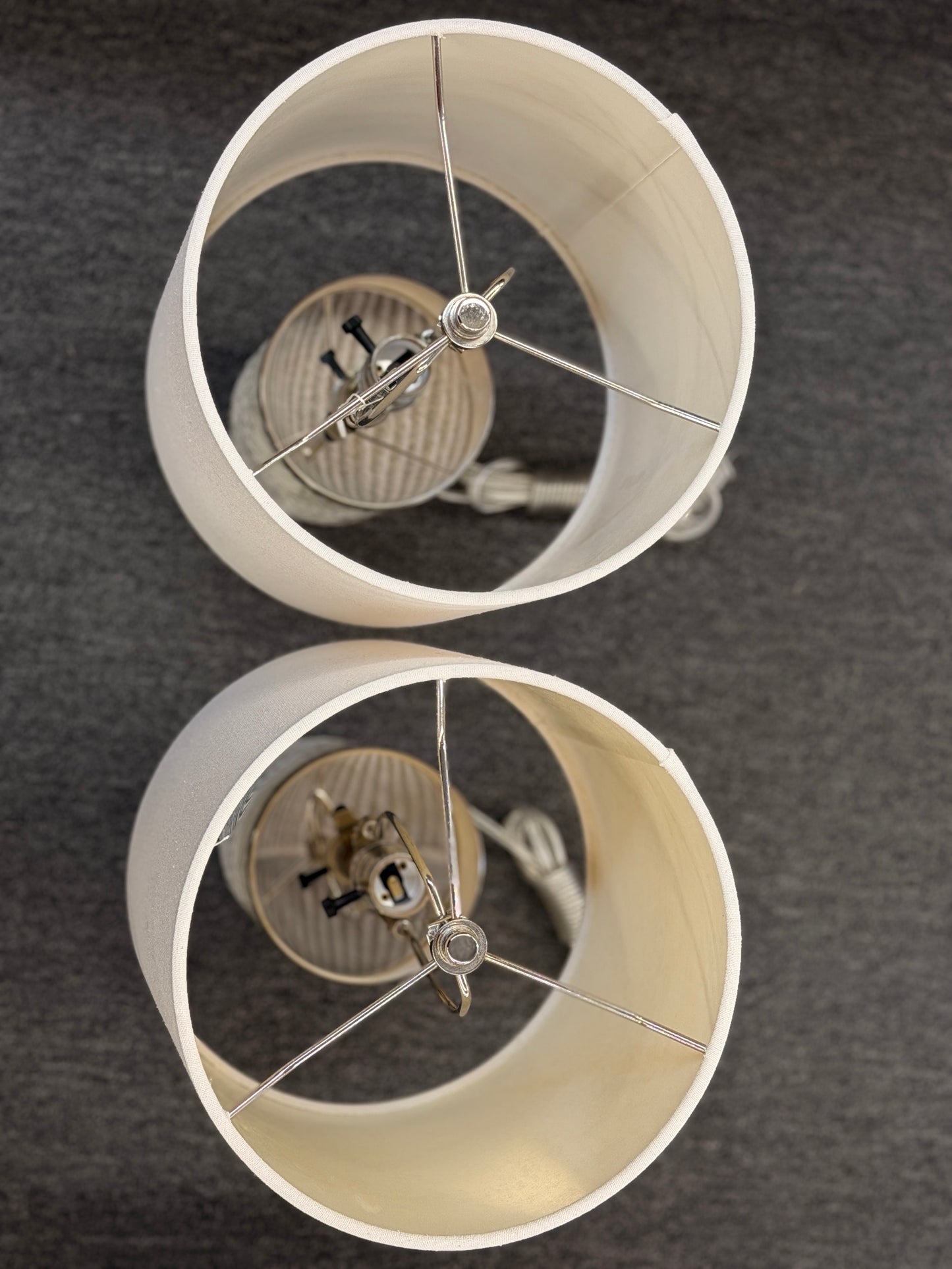 A pair of identical table lamps featuring textured white cylindrical ceramic bases with a geometric diamond pattern, white drum shades, and silver-toned hardware.