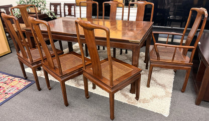 A 9-piece traditional wooden dining set featuring a large rectangular table, two matching armchairs, and six side chairs with woven rattan backrests.