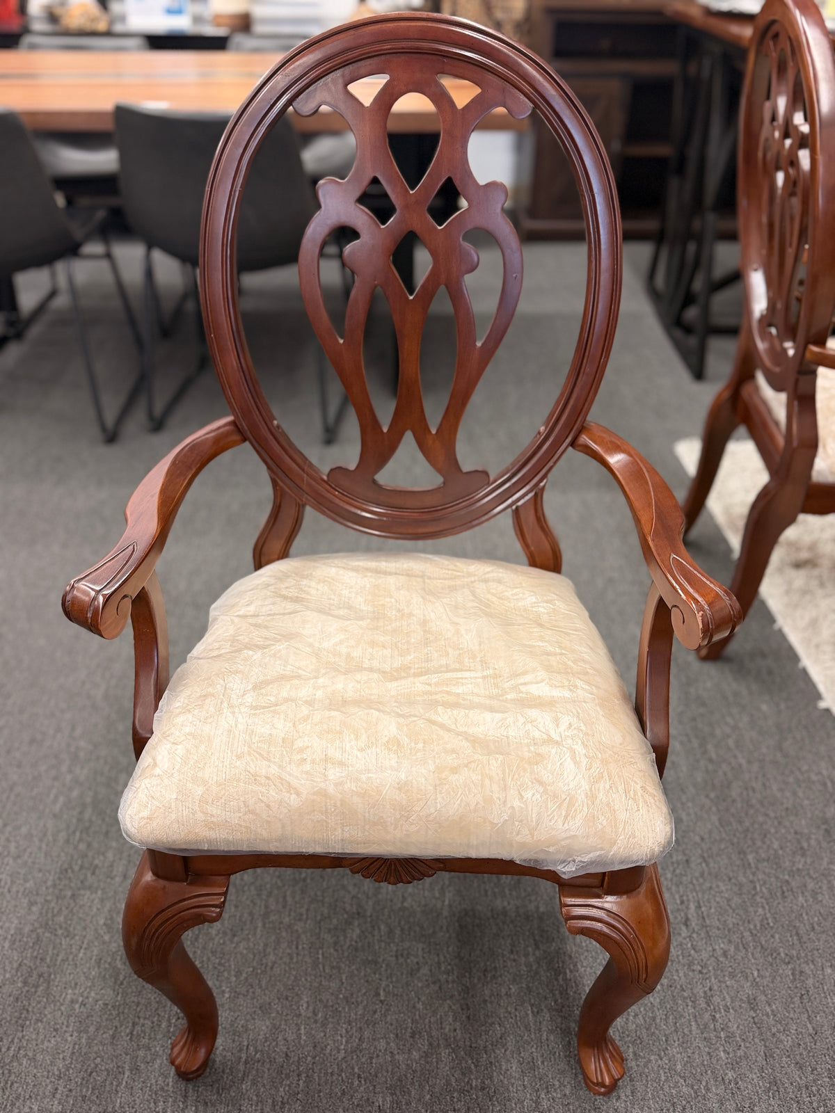 A traditional dark wood dining set including a rectangular table and four chairs with ornate backrests and light upholstered seats in excellent condition.
