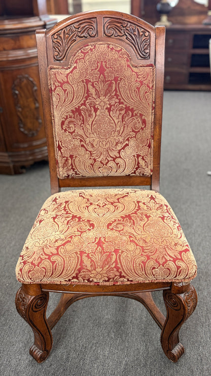 An ornate traditional dark wood dining table with wood-inlay details surrounded by six matching high-back chairs upholstered in red and gold damask fabric in excellent condition.