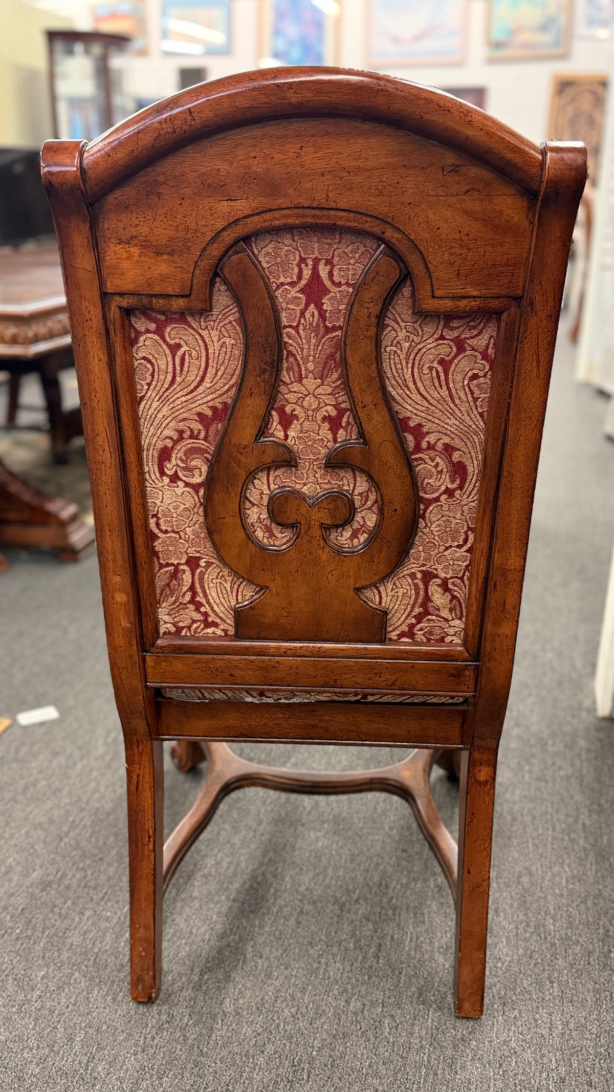 An ornate traditional dark wood dining table with wood-inlay details surrounded by six matching high-back chairs upholstered in red and gold damask fabric in excellent condition.