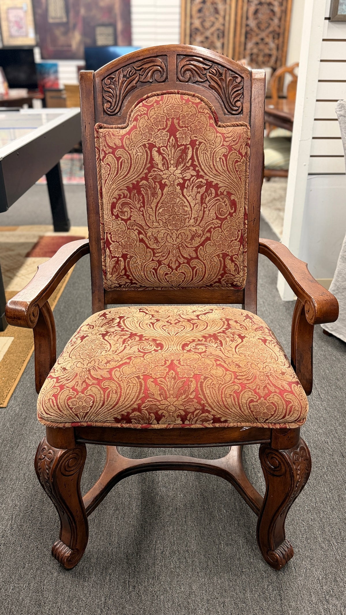 An ornate traditional dark wood dining table with wood-inlay details surrounded by six matching high-back chairs upholstered in red and gold damask fabric in excellent condition.