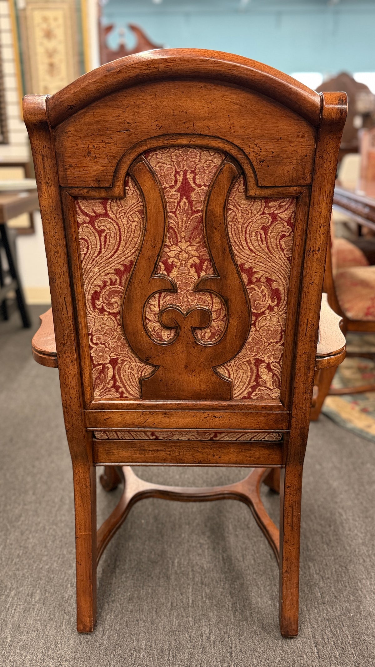 An ornate traditional dark wood dining table with wood-inlay details surrounded by six matching high-back chairs upholstered in red and gold damask fabric in excellent condition.