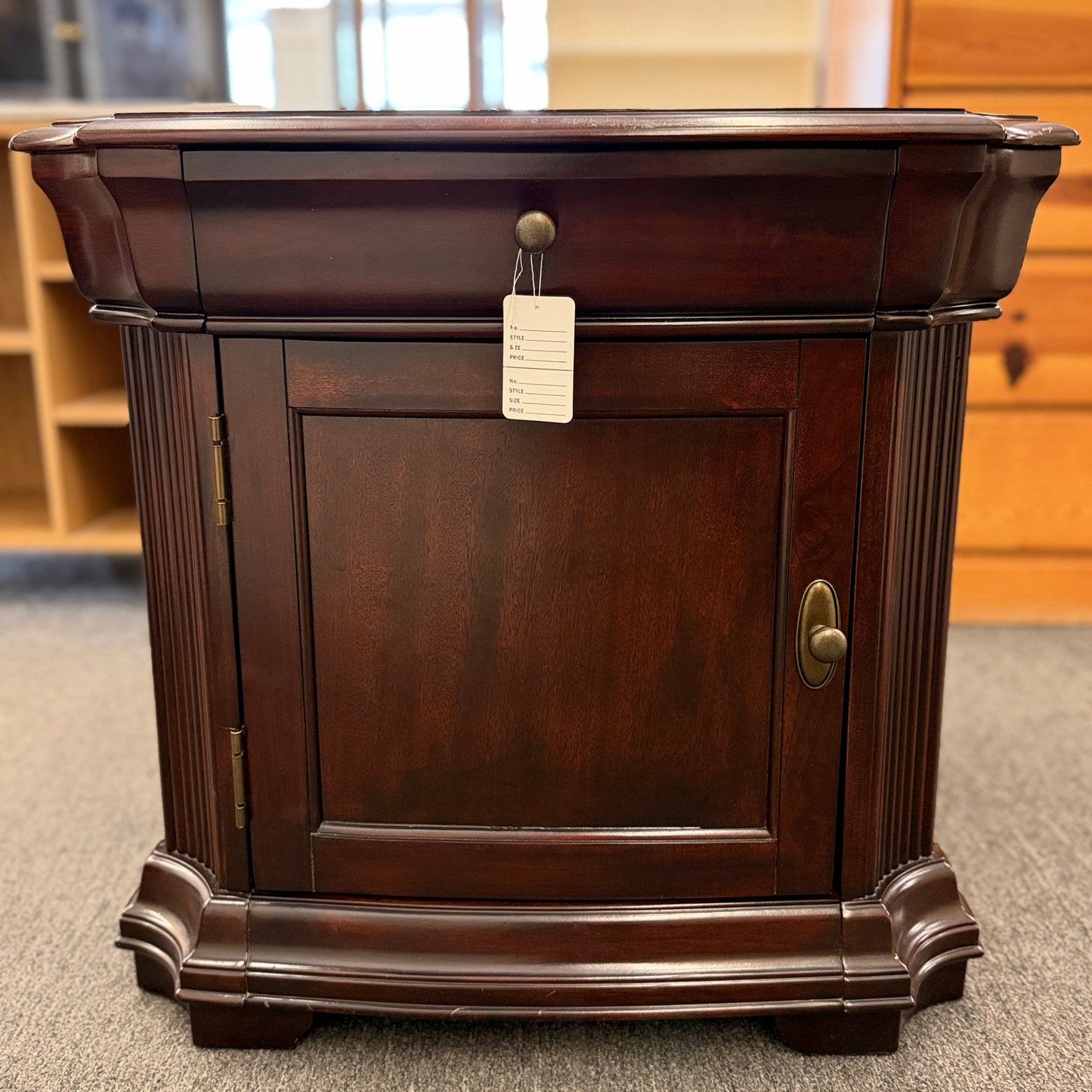 Traditional dark wood nightstand featuring a top drawer, lower cabinet door, fluted corner details, and a classic timeless design.