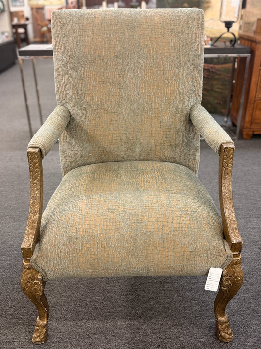 A high-back traditional accent armchair upholstered in a textured light-sage and gold fabric with gilded carved wooden arms, cabriole legs, and claw-and-ball feet in good condition.