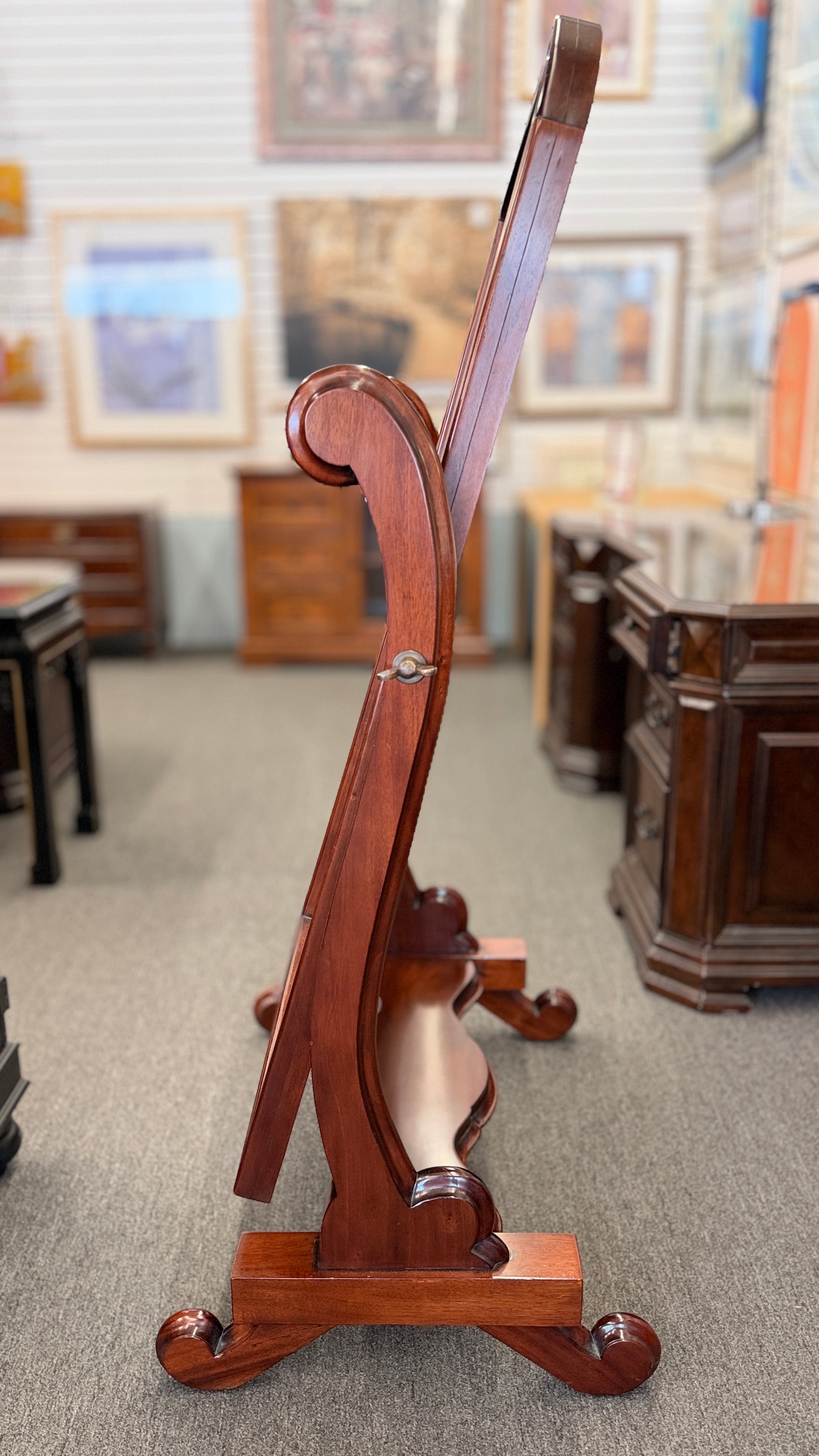 Traditional freestanding oval cheval mirror with a polished wood frame, adjustable full-length mirror, decorative scrolled legs, and a sturdy wooden base.
