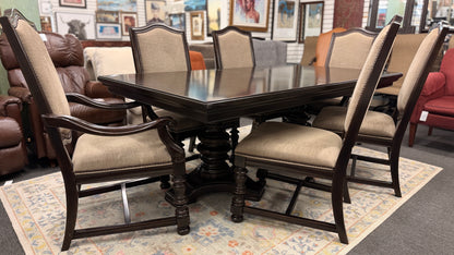 A traditional 7-piece dining set featuring a large rectangular wooden table, two high-back host armchairs, and four matching side chairs with fabric upholstery.