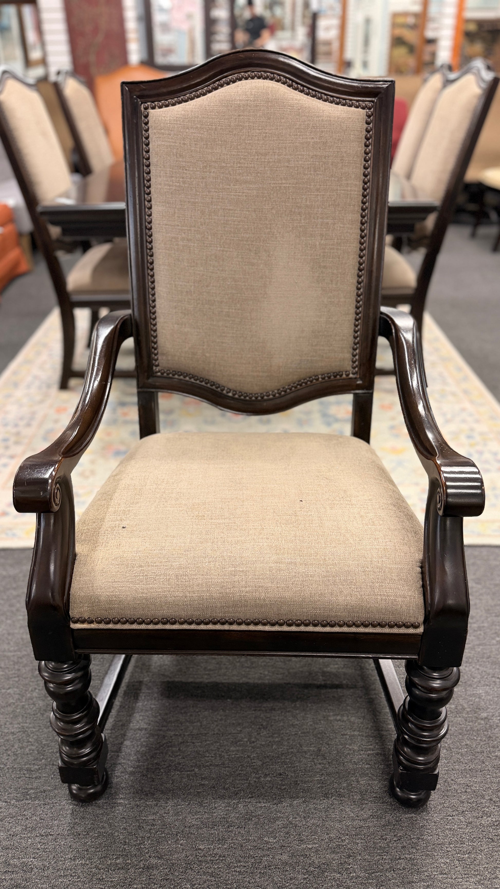 A traditional 7-piece dining set featuring a large rectangular wooden table, two high-back host armchairs, and four matching side chairs with fabric upholstery.
