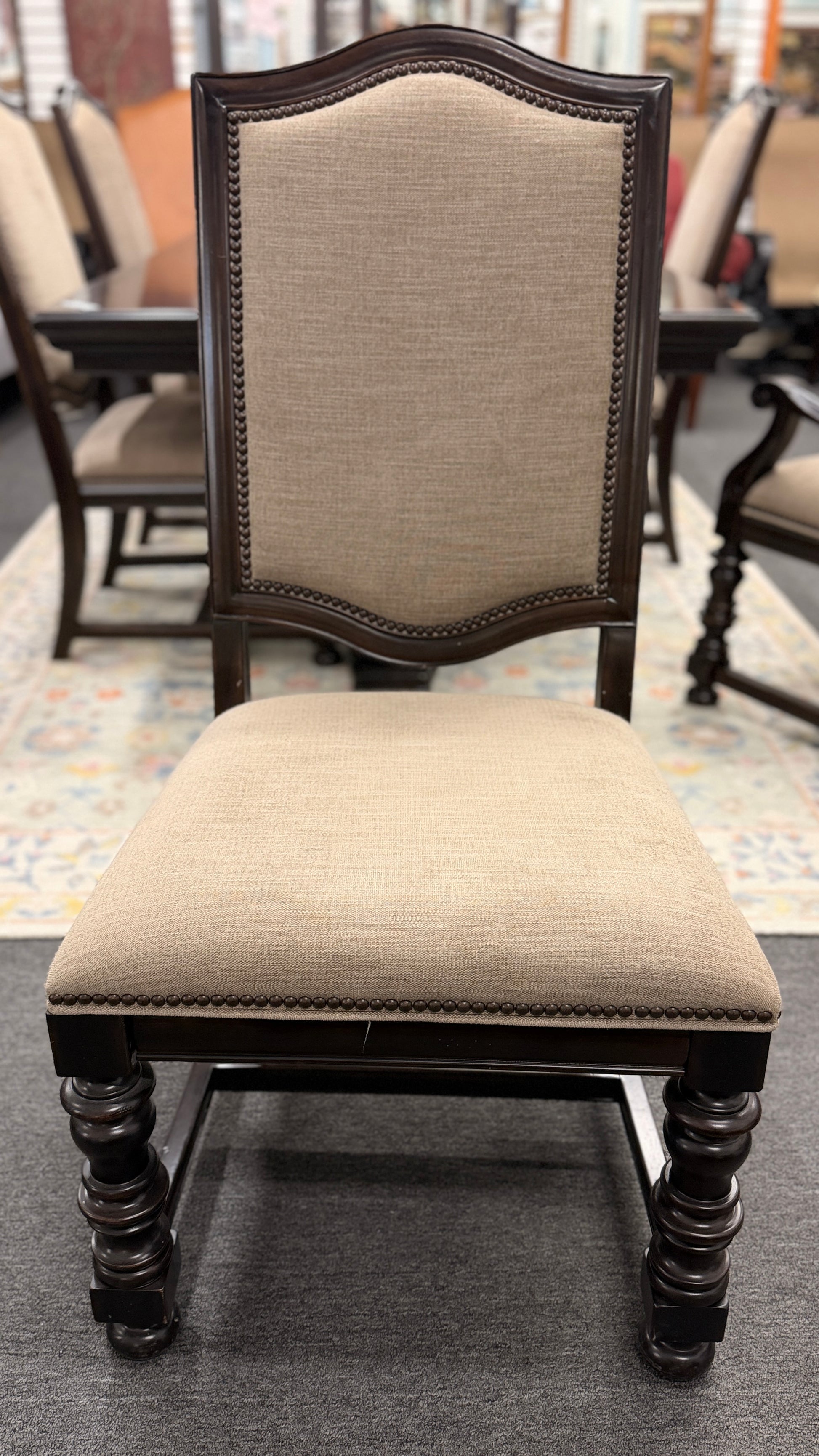 A traditional 7-piece dining set featuring a large rectangular wooden table, two high-back host armchairs, and four matching side chairs with fabric upholstery.