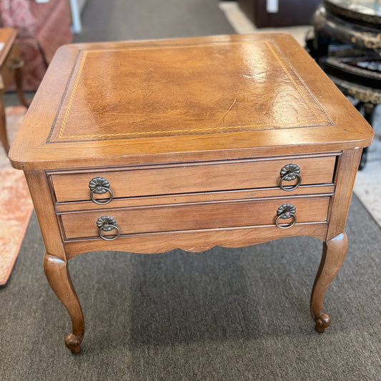 A square wooden end table featuring decorative gold inlay, two stacked drawers with ornate ring pulls, and cabriole legs.