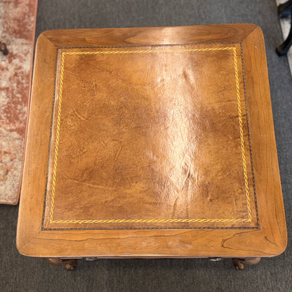 A square wooden end table featuring decorative gold inlay, two stacked drawers with ornate ring pulls, and cabriole legs.