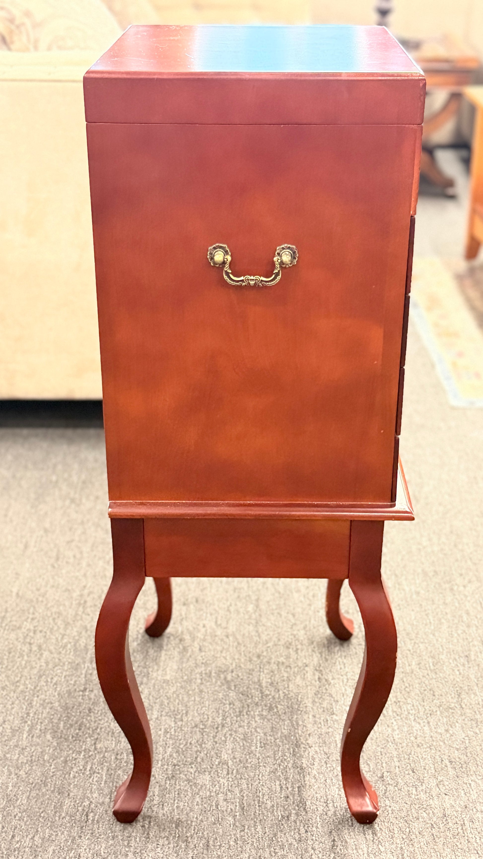 A tall, upright wooden jewelry or silverware chest shown open, revealing a ring-roll top compartment, five stacked drawers, burgundy fabric lining, and metal pulls.