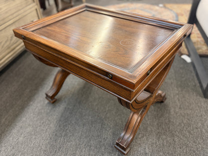 Traditional rectangular wood coffee table featuring a raised-edge tabletop, curved trestle-style legs, and decorative metal nailhead trim along the apron.