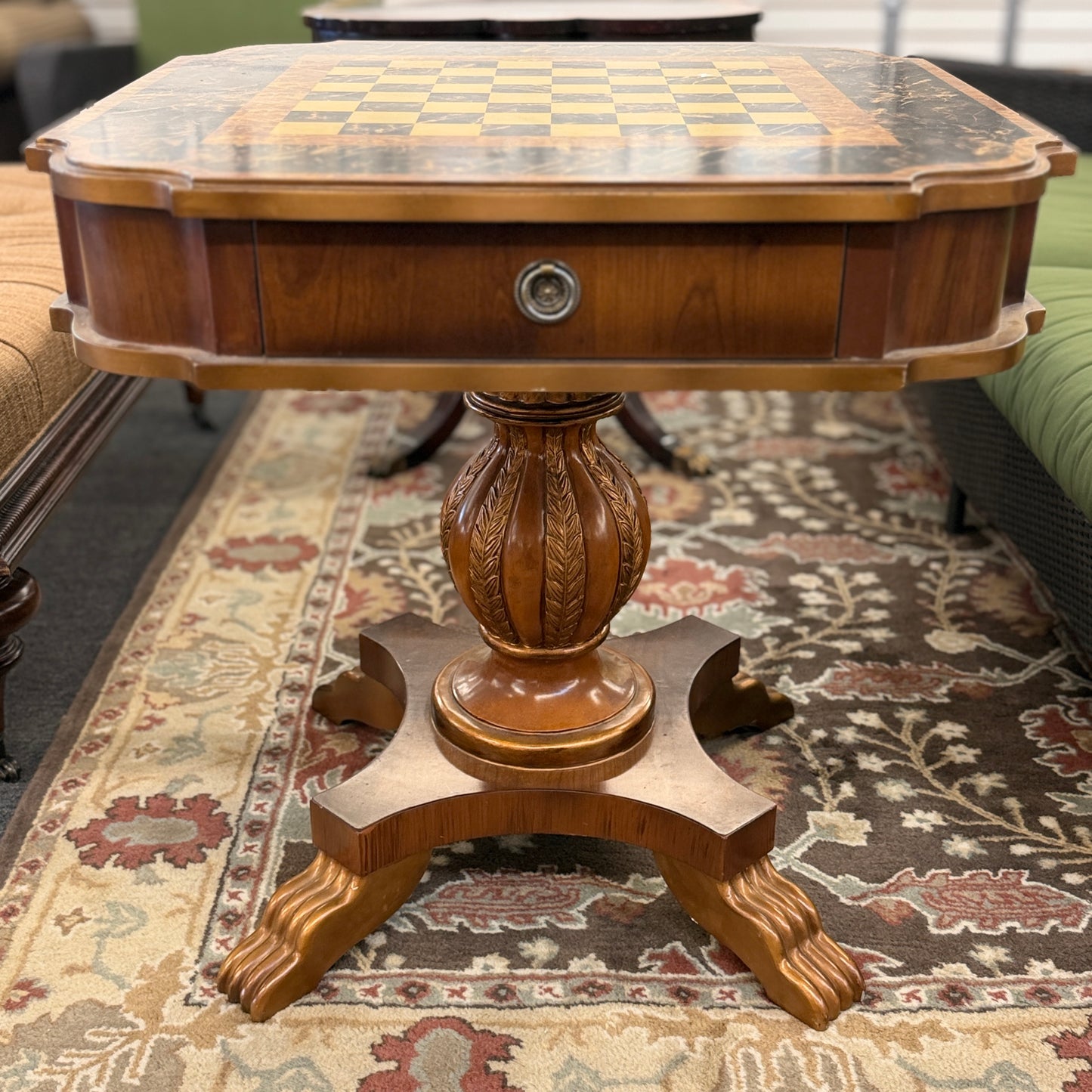 A traditional wooden pedestal chess table featuring a built-in inlaid chessboard surface, a single storage drawer with a ring pull, and a carved urn-shaped pedestal base.
