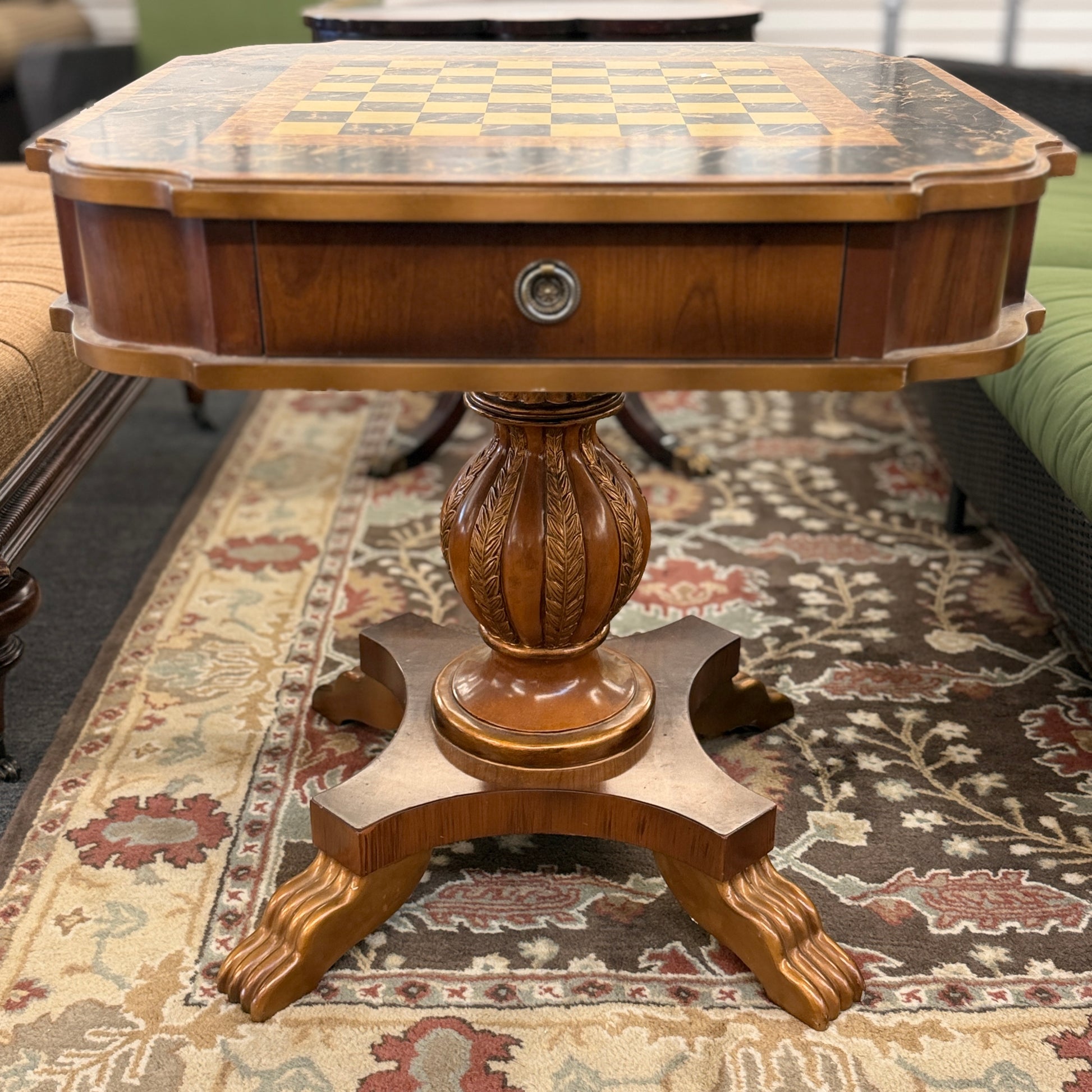 A traditional wooden pedestal chess table featuring a built-in inlaid chessboard surface, a single storage drawer with a ring pull, and a carved urn-shaped pedestal base.
