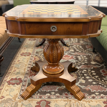 A traditional wooden pedestal chess table featuring a built-in inlaid chessboard surface, a single storage drawer with a ring pull, and a carved urn-shaped pedestal base.