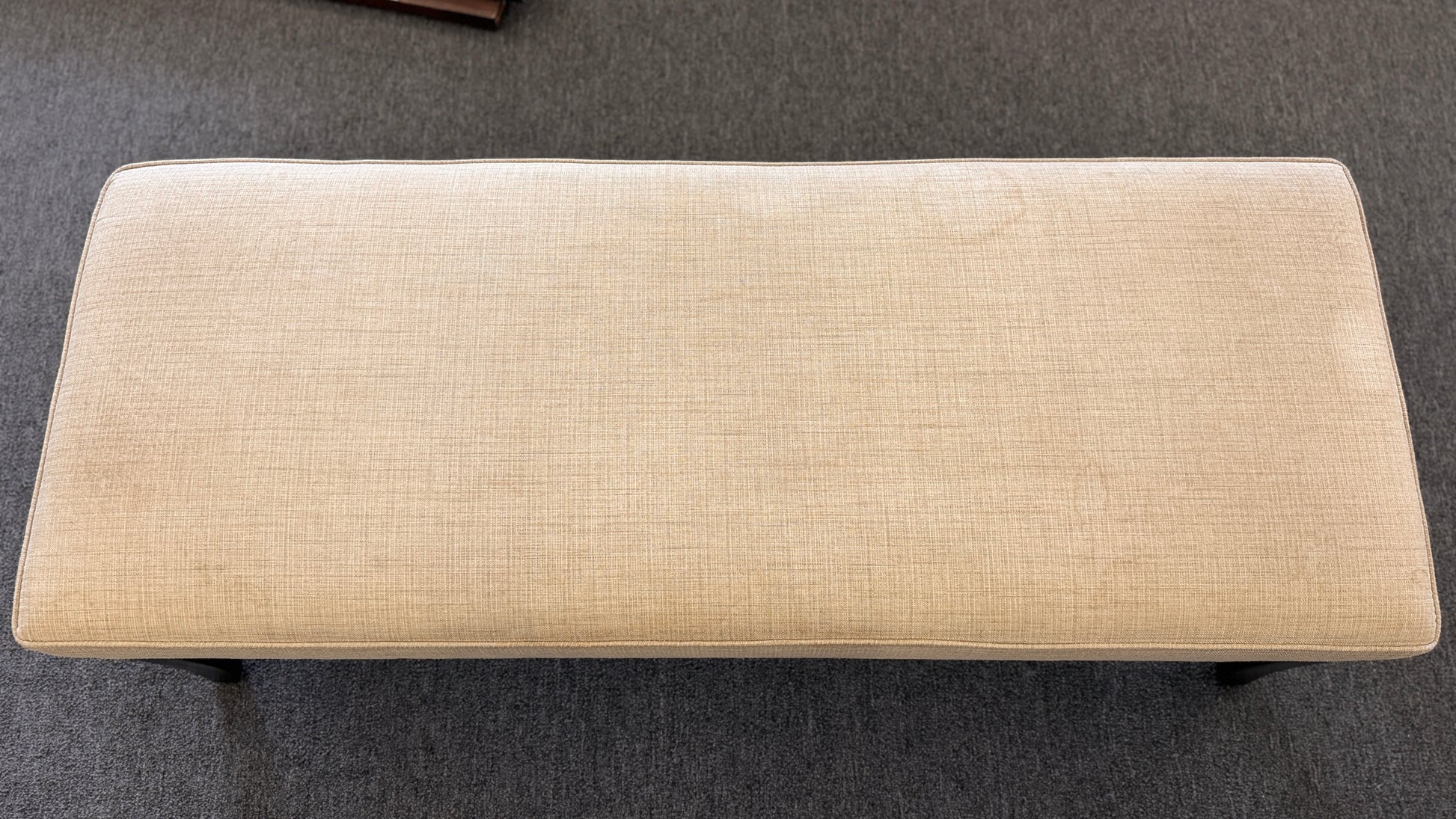 A 52-inch wide upholstered bedroom bench featuring a cushioned fabric top supported by a sturdy wooden frame.
