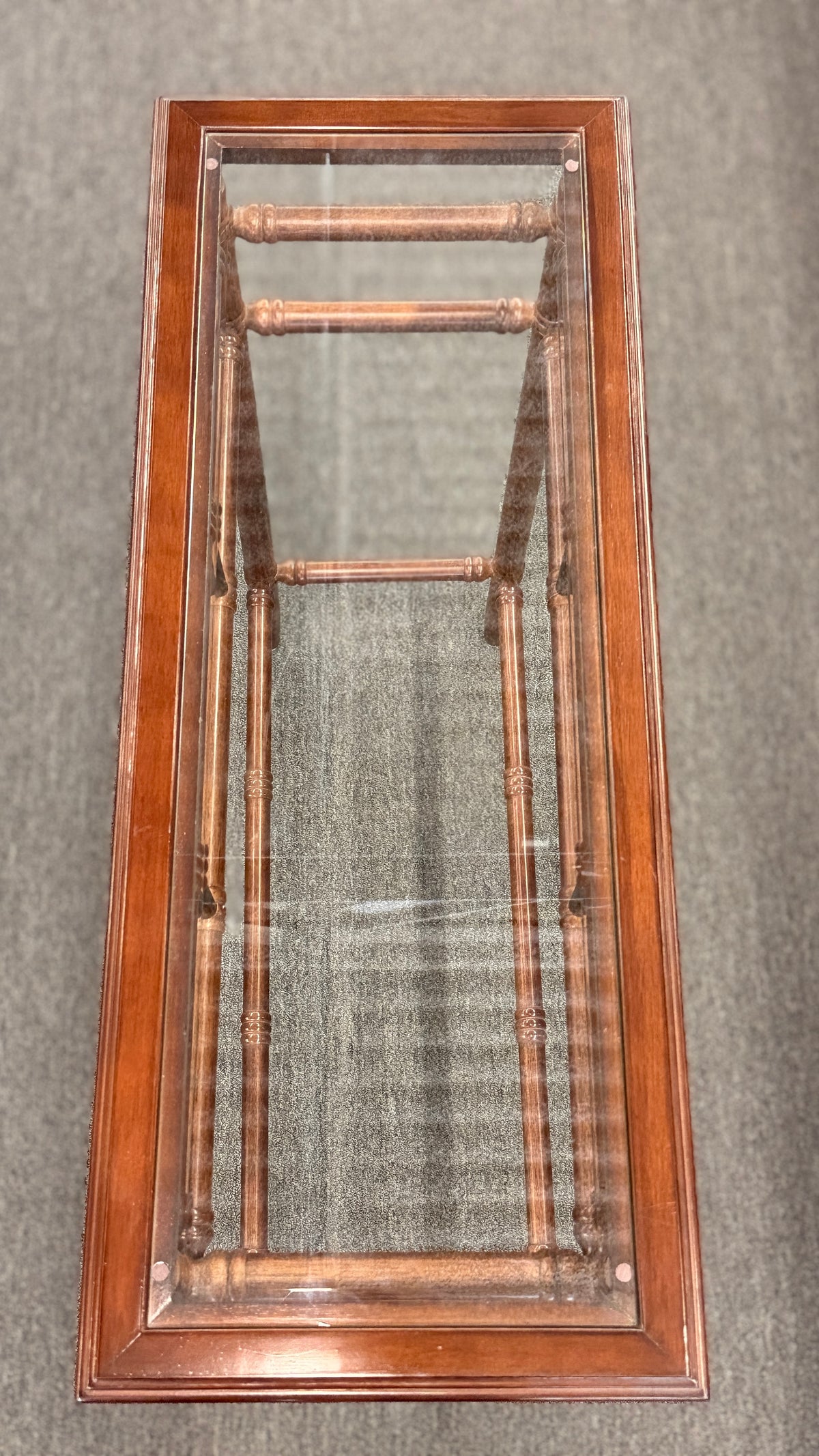 A vintage console sofa table featuring a clear glass top insert set in a faux-bamboo carved wood frame with turned stretchers in good condition.