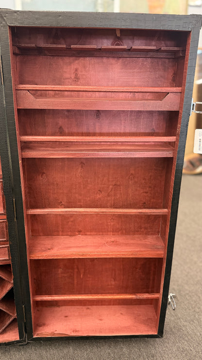 A tall hinged trunk-style bar cabinet featuring interior shelving, small utility drawers, and a lower lattice rack for wine bottle storage.