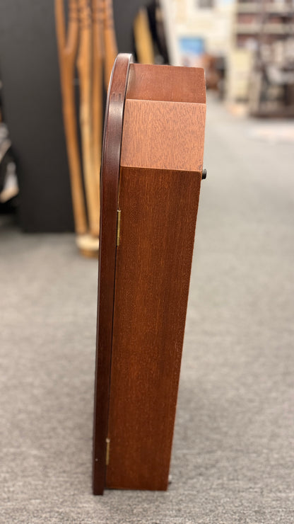 A traditional Waltham 31-day chime mantel clock in an arched cherry-finish wood case with a Roman numeral dial and brass pendulum in excellent condition.