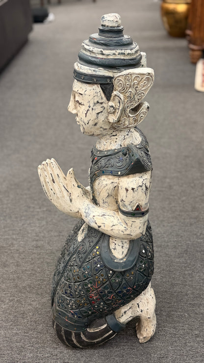 Traditional kneeling Buddhist or Southeast Asian deity statue finished in a distressed weathered white and black wash with intricate mirrored and jeweled accents in excellent condition.