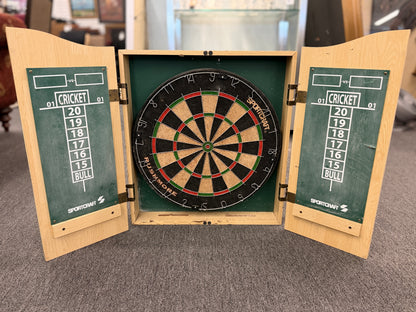 Wood dartboard cabinet opened to reveal a classic bristle dartboard with green Cricket scoreboards on the inside of both cabinet doors.