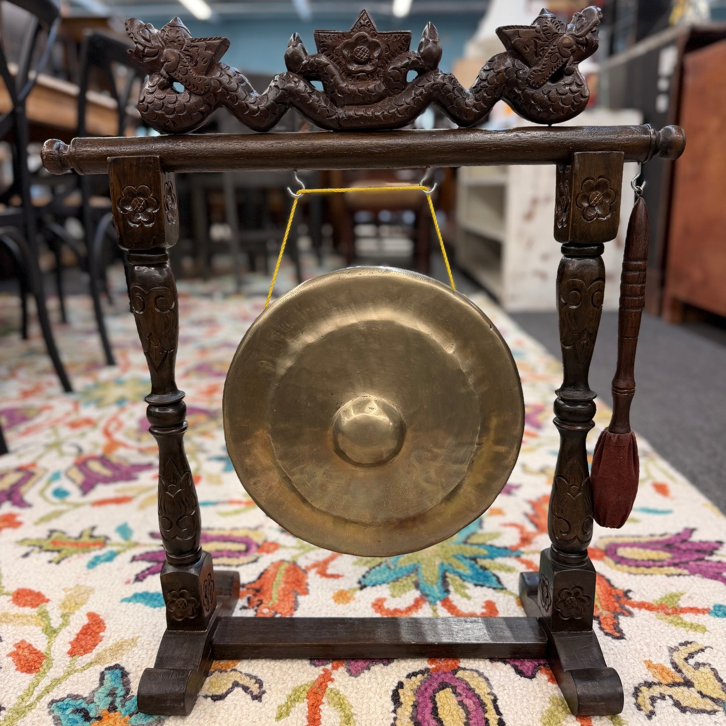 Traditional hand carved wood framed brass gong accent piece with intricate carvings on the stand, including a hanging mallet, at 2nd Debut Houston consignment showroom