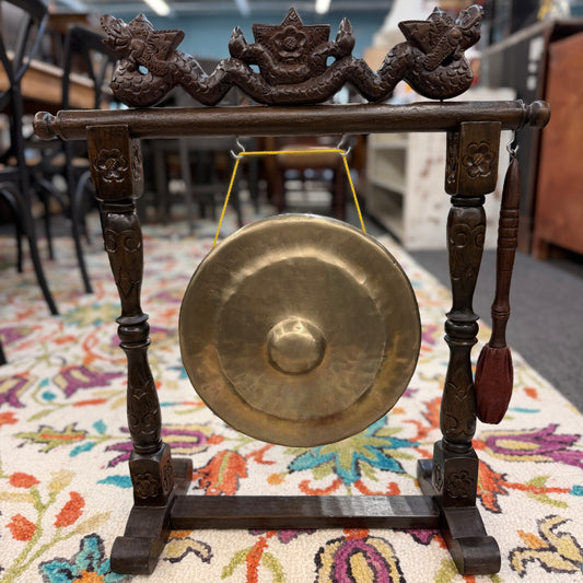 Traditional hand carved wood framed brass gong accent piece with intricate carvings on the stand, including a hanging mallet, at 2nd Debut Houston consignment showroom