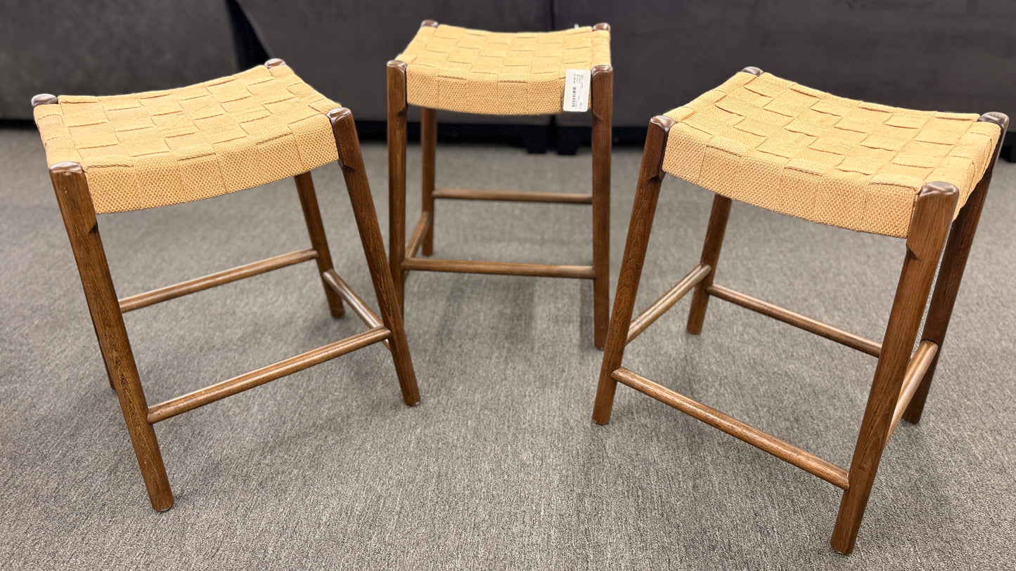 A set of three wooden backless barstools featuring woven natural-fiber seats in good condition.