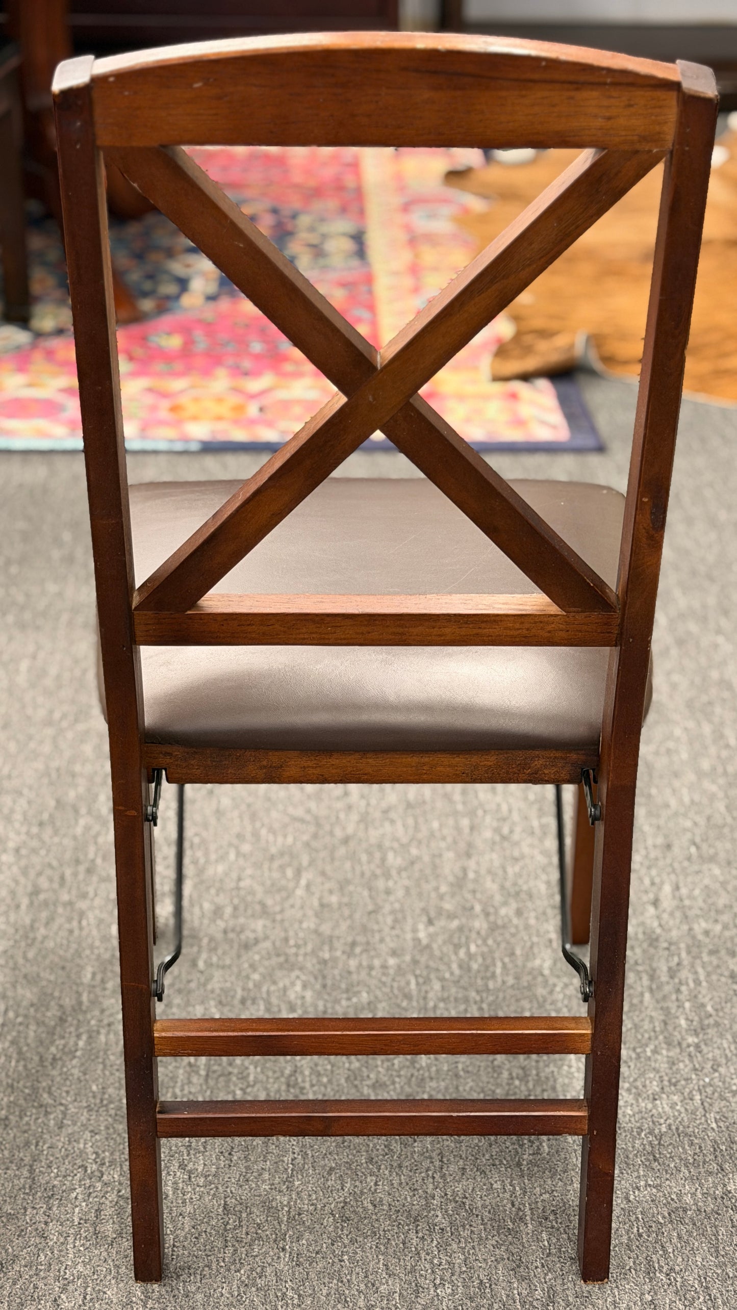 A wooden folding dining table set featuring a dark brown inset playing surface and four matching folding chairs with dark brown upholstered seat cushions.