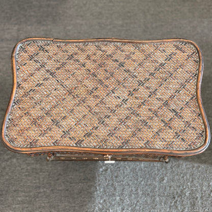 A woven rattan storage chest with a latching lid, a textured front panel, and short wooden legs in good condition.